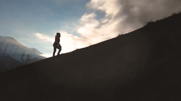 Very Long Shot Aerial View of Epic Shot of a Girl Walking on the Edge of the Mountain As a