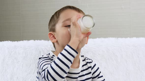 The Child Drinks a Milk Drink - Kefir, Smoothies, Cocktail, Yogurt, A Little Boy Drinks a Drink From