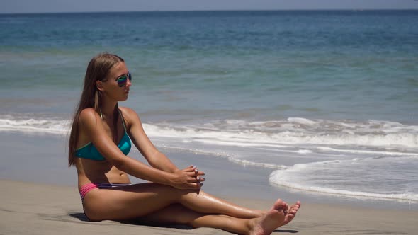 Girl in the Sun Glasses Sits on the Beach