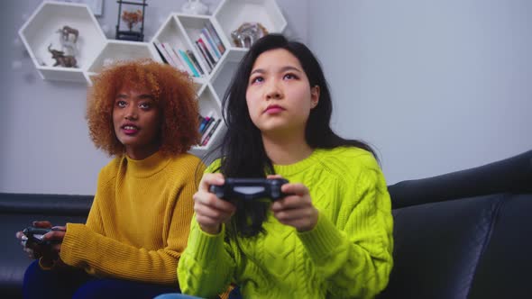 Two Young Woman Using Joystick Controller Playing Video Game On. Competition Win and Loss