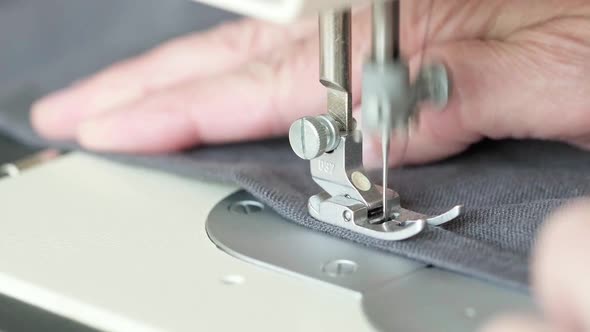 Hands of Seamstress Sewing with a Professional Machine Sewing Workshop