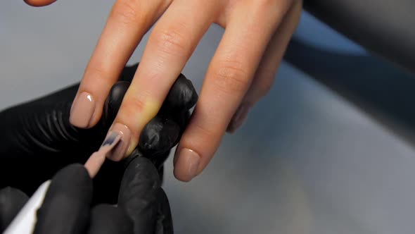 Beauty Salon Worker Applies Layer of Coloured Gel on Nail