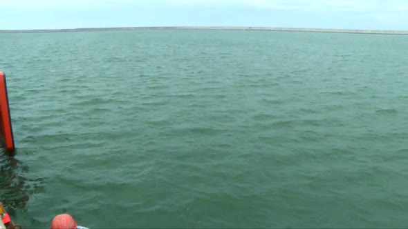 tilt down from the ocean to a man drilling floating on a platform