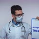 Male Doctor Wearing a Stethoscope Holding Poster with a Text OCCUPATIONAL THERAPY - VideoHive Item for Sale