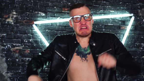 Handsome Young Man with Glasses in Leather Jacket on Naked Body with Tattoo on Chest Shouting and