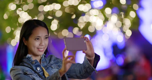 Woman take photo on mobile at night