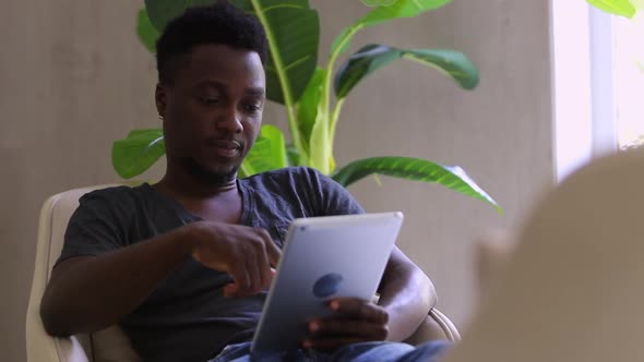 Thoughtful Smart Black Male Reading Ebook Nodding and Thinking Spbi