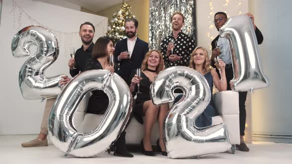 Group of Friends Holding Inflatable Foil Numerals 2021