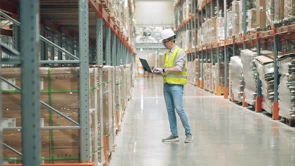 Warehouse with a Male Worker Conducting Stocktaking