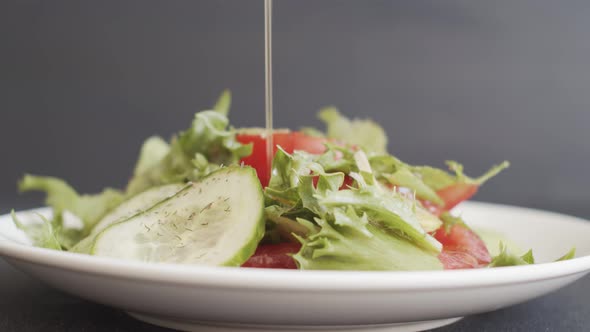 Adding Olive Oil To Fresh Green Vegetable Salad