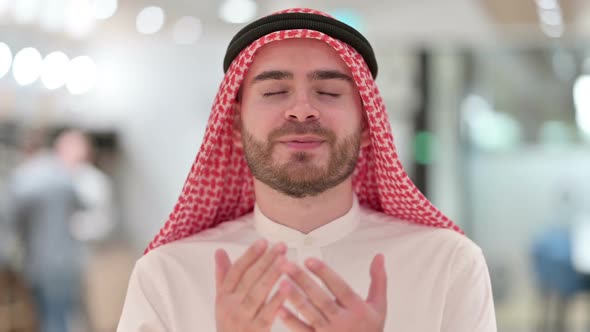 Portrait of Religious Young Arab Businessman Praying alt