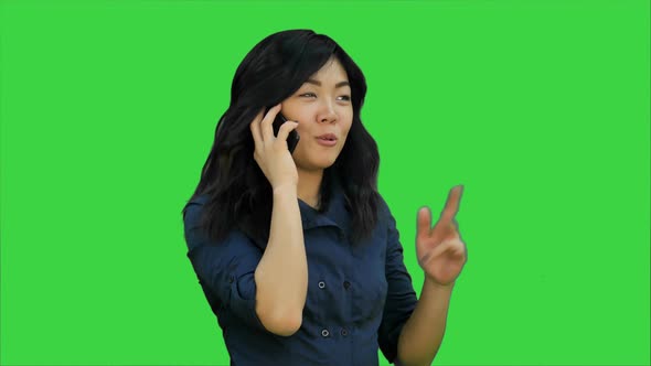 Positive and Happy Asian Woman Talking on a Cell Phone on a Green Screen, Chroma Key