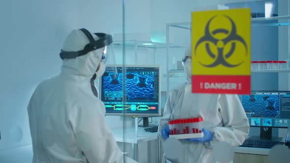 Worried Scientists in Ppe Suit Talking Behind the Glass Wall