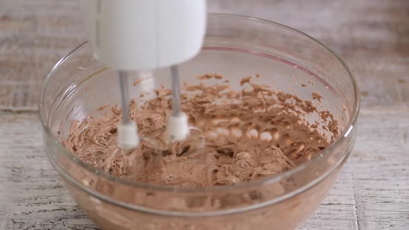 A Baker with Hand Mixer Whip Up Some Chocolate Buttercream Frosting