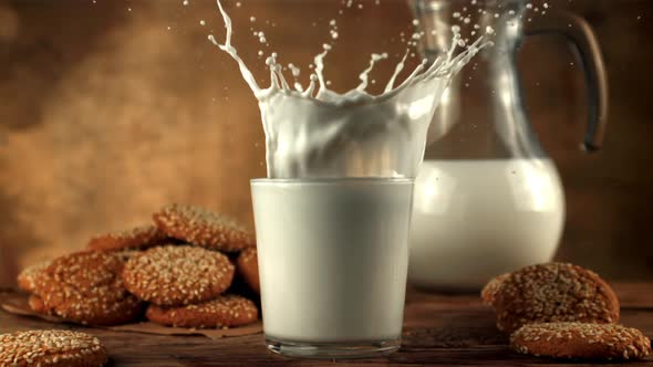 Super Slow Motion Oatmeal Cookies Falls Into a Glass of Milk with Spray