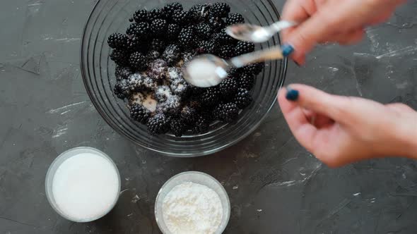 The process of making a blackberry pie. Berries sprinkled with powdered sugar