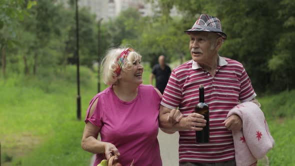 Family Weekend Picnic. Active Senior Old Grandparents Couple in Park. Husband and Wife Walk Together