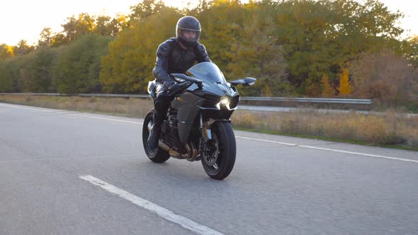 Man in Helmet Riding Fast on Modern Sport Motorbike at Highway. Motorcyclist Racing His Motorcycle alt