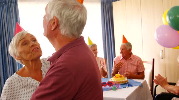 Senior couple dancing while celebrating birthday with friends
