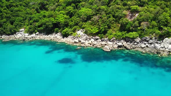 Calm Sea Near Tropical Volcanic Island. Drone View of Peaceful Water of Blue Sea Near Stony Shore