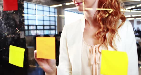 Woman writing on sticky notes