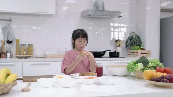 Girl tasting bread and fruit jam