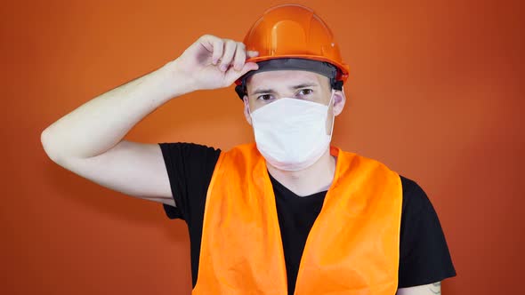 Portrait of Young Man in Medical Mask on His Face on Orange Background