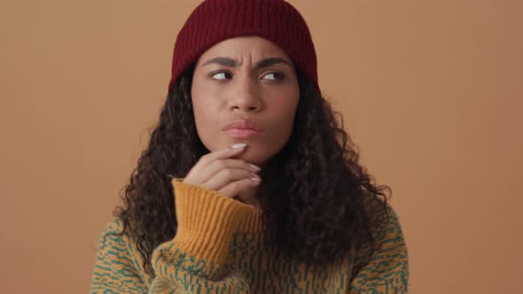 Pensive African curly-haired woman looking to the sides