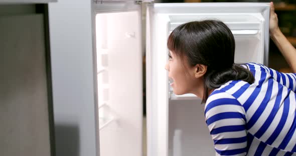 Woman feeling hungry and open refrigerator for food