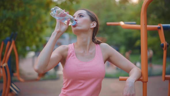 Sportive Woman Standing Summer Day on Sport Ground Resting After Hard Training Drink Water Plastic