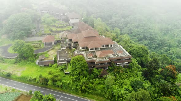 Gliding aerial view of spooky abandoned hotel in upland Bali