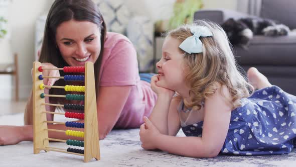 Caucasian mother and daughter having fun using abacus