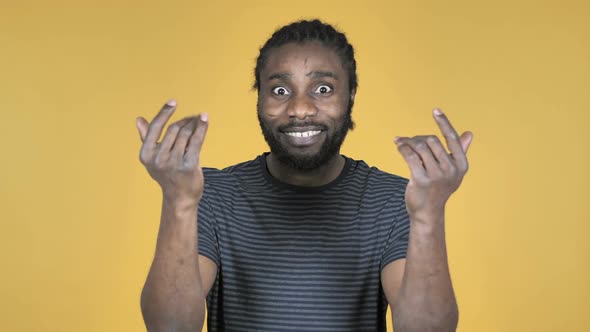 Casual African Man Inviting Customers with Both Hands Isolated on Yellow Background