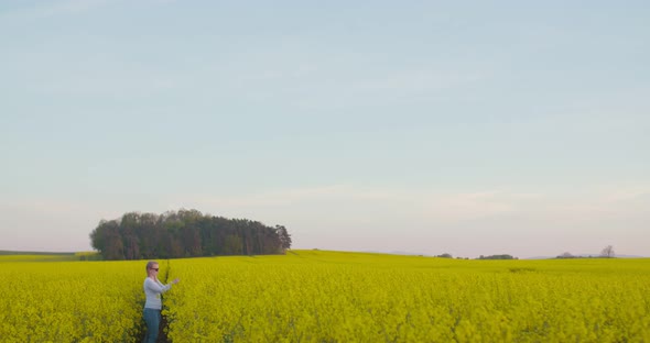 Female Farmer Examining Oilseed Rape Field