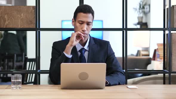 Pensive Businessman Working on Laptop