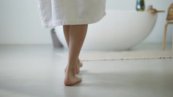 Elegant Woman Walk to the Bath Then She Takes Off Her White Bathrobe and Climbs Into the Bathroom