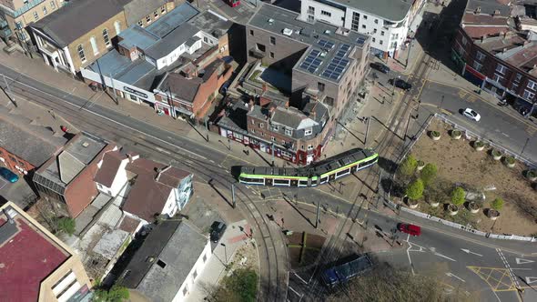 Drone shot over Croydon old town following a modern green tram