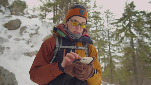 Woman Using Map on Phone during Winter Hike