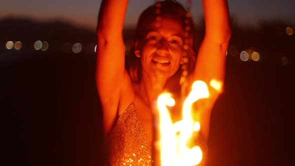 Woman fire dancer spinning flames at the beach