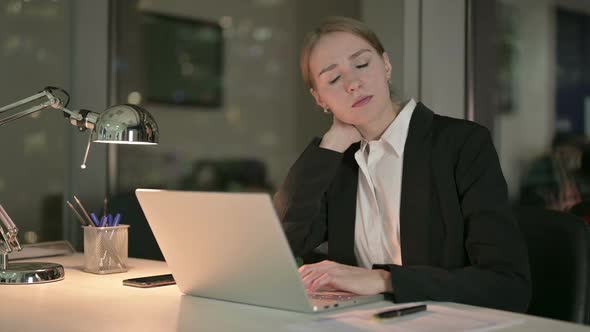 Tired Businesswoman Having Neck Pain While Working at Night