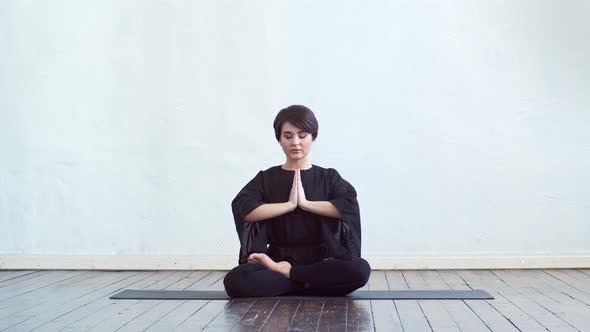 Young and fit woman practicing yoga indoor in the class.