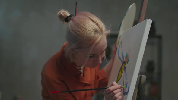 Woman Painter Creating Masterpiece on Easel in Studio