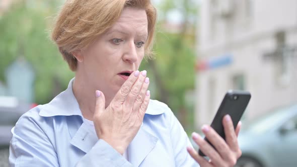 Outdoor Old Woman Reacting To Loss on Smartphone