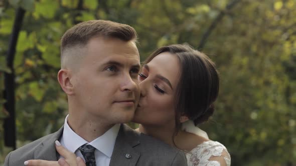 Lovely Newlyweds Caucasian Bride Embracing Groom in Park Making Kiss Wedding Couple Family Hugging