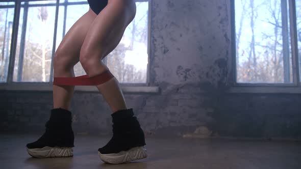 Legs of Sporty Woman Taking Steps with Rubber Band