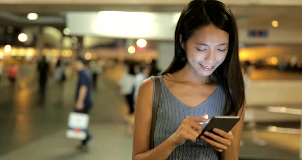 Woman working on smart  phone in the city at night 