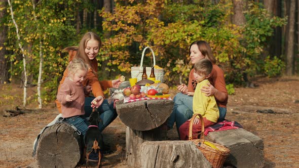 Mothers with Children and a Dog at a Picnic in the Forest