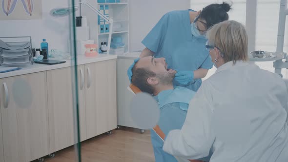 Stomatologist and Nurse Using Dental Tools to Examine Dentition Work