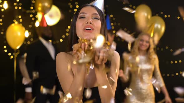 Joyful Asian Blowing Confetti and Sending Air Kiss Camera, Party Entertainment