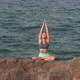 Young Woman Tries Yoga in Lotus Position on Rock Against Sea - VideoHive Item for Sale